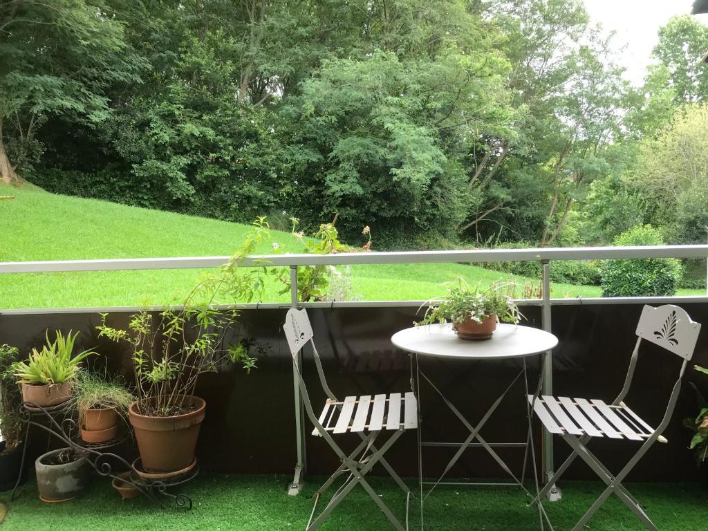 un patio avec deux chaises et une table avec des plantes dans l'établissement A l orée du lac Moriscot, chouette T3, idéale famille ,4 à 6 personnes, très bien desservie, à Biarritz
