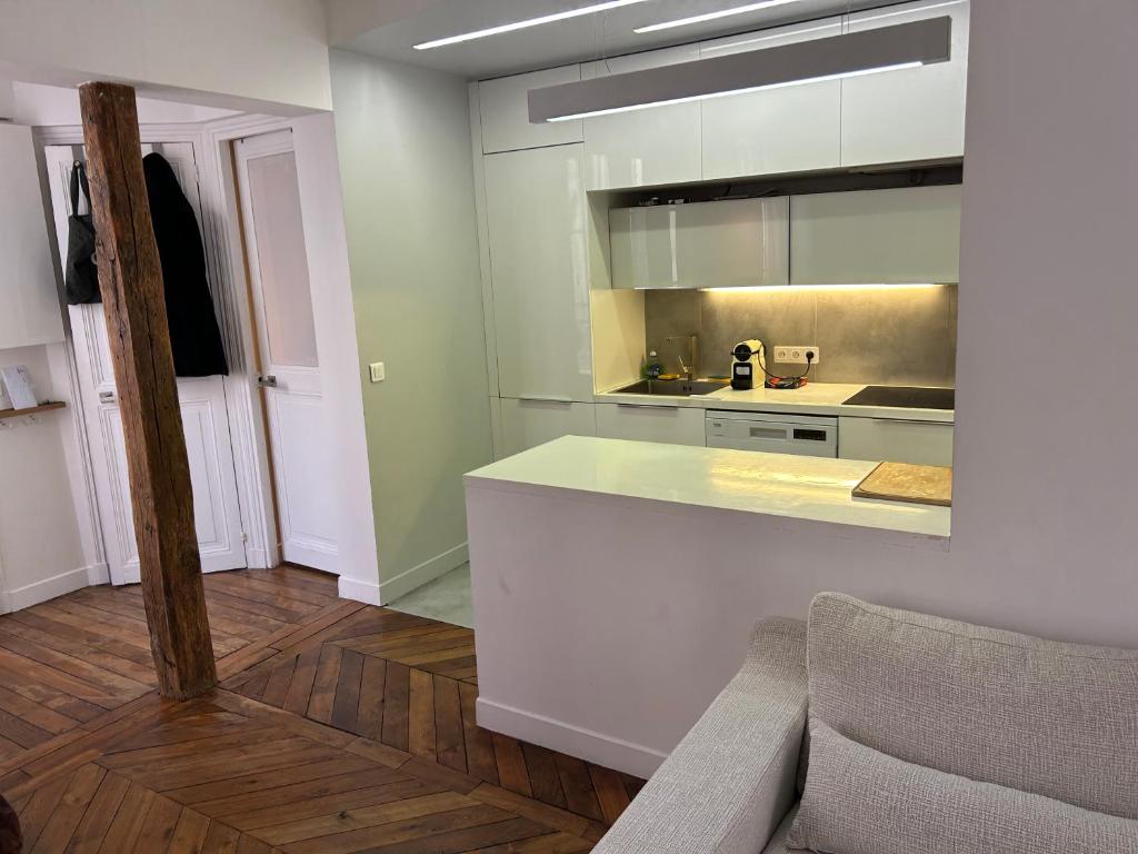 - une cuisine avec un comptoir blanc dans une pièce dans l'établissement Typical Parisian flat Central Paris by Montmartre, à Paris