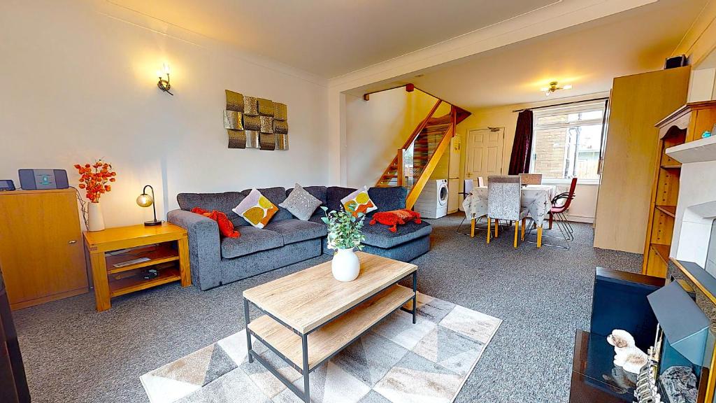 a living room with a blue couch and a table at Sleeps 10, Free parking, close to Science Park, King size bed in Milton