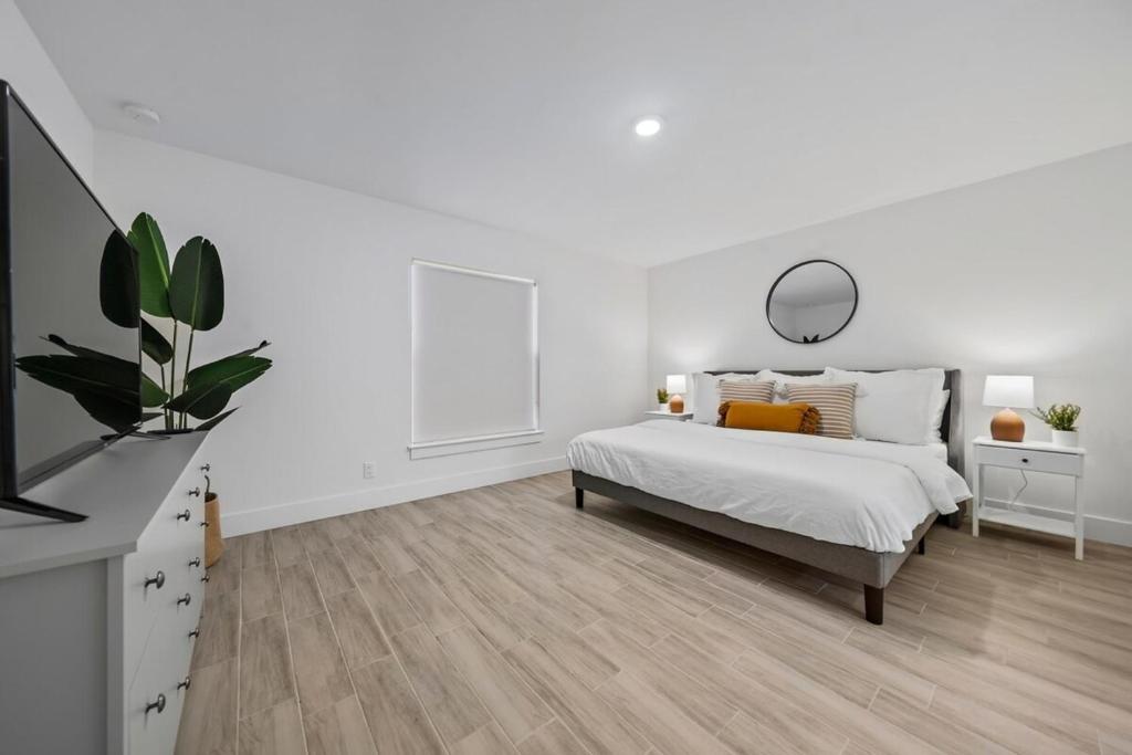 a white bedroom with a bed and a mirror at New! Few Minutes To Downtown, 10 To The Beach! in West Palm Beach