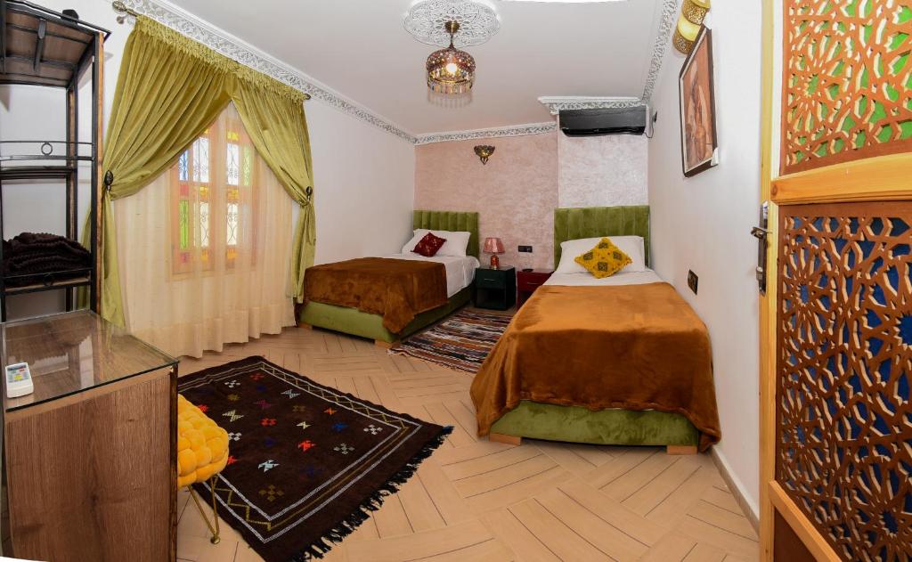 a hotel room with two beds and a tv at Appart Sahraoui Medina in Fès al Bali