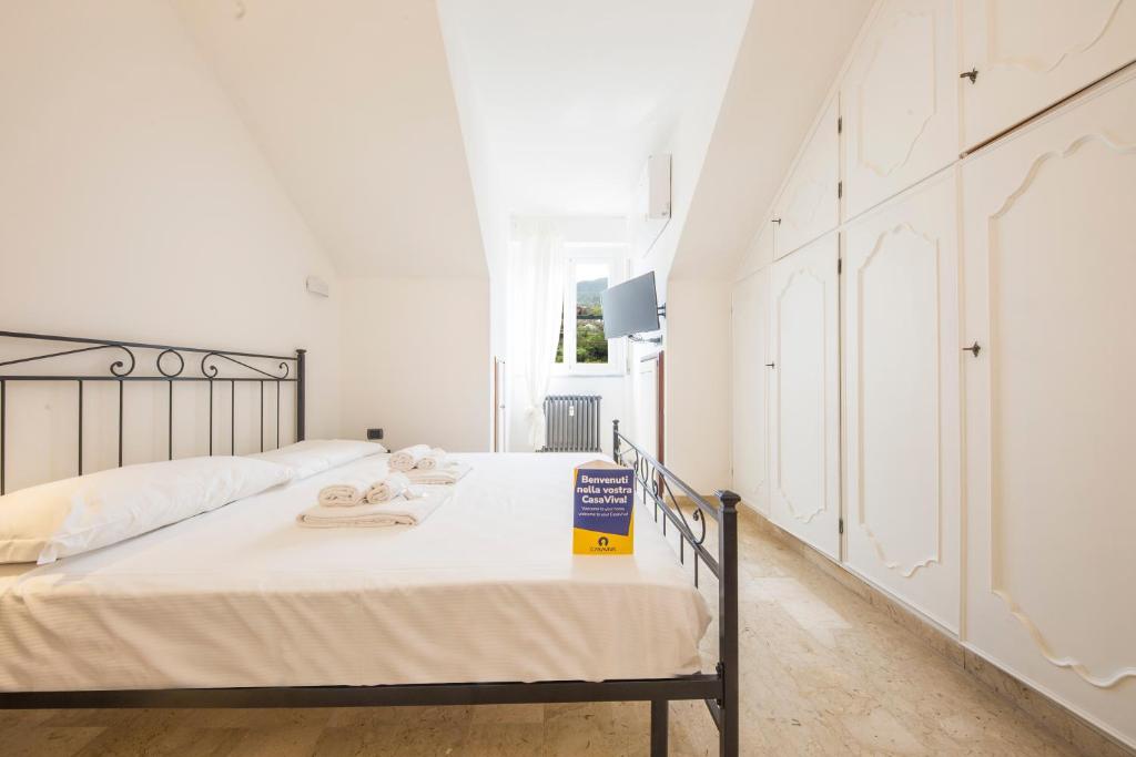 サンタ・マルゲリータ・リグレにあるCasaViva - Elegant Retreat in Santa Margherita Lの白いベッドルーム(タオル付きのベッド付)