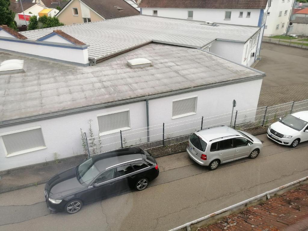 Zwei Autos parkten auf einem Parkplatz neben einem Haus in der Unterkunft OAz in Ehingen