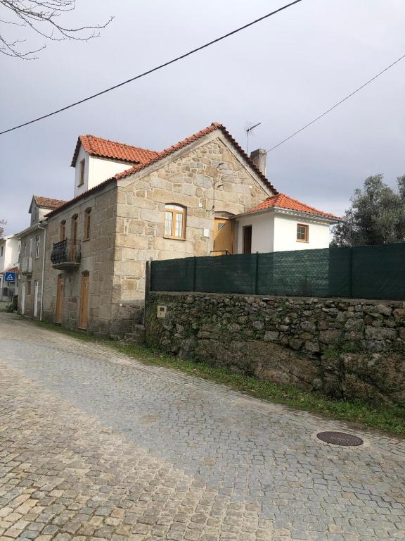 a stone building next to a brick wall at Serra da Estrela - Casa Castro in Gouveia