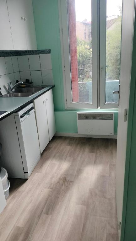 Il comprend une cuisine dotée de parquet et d'une grande fenêtre. dans l'établissement 12 RUE FERNAND HE93600 Aulnay SOUS BOIS, à Aulnay-sous-Bois
