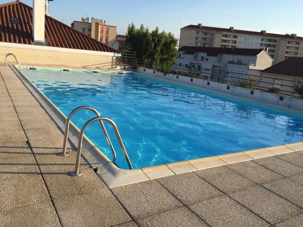 - une grande piscine bleue au-dessus d'un bâtiment dans l'établissement Appartement avec piscine sur le toit, à Villeurbanne