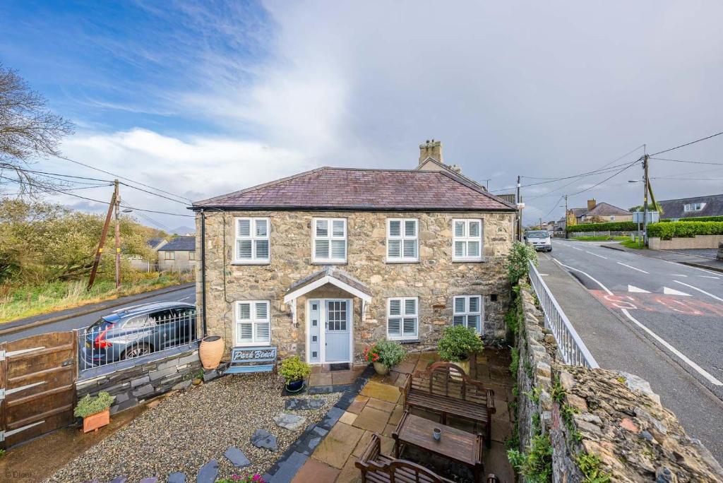 a brick house with a white door on a street at Saerdy in Morfa Nefyn