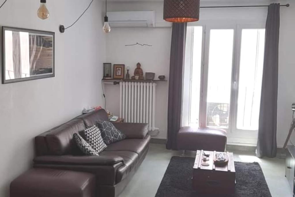 - un salon avec un canapé en cuir et une table basse dans l'établissement Appart 6 personnes, 3 chambres, très bien situé Centre, à Marseille