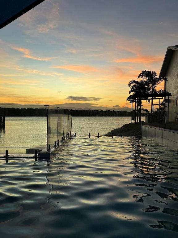 a pool of water with a sunset in the background at Lucinda Cove Resort in Lucinda