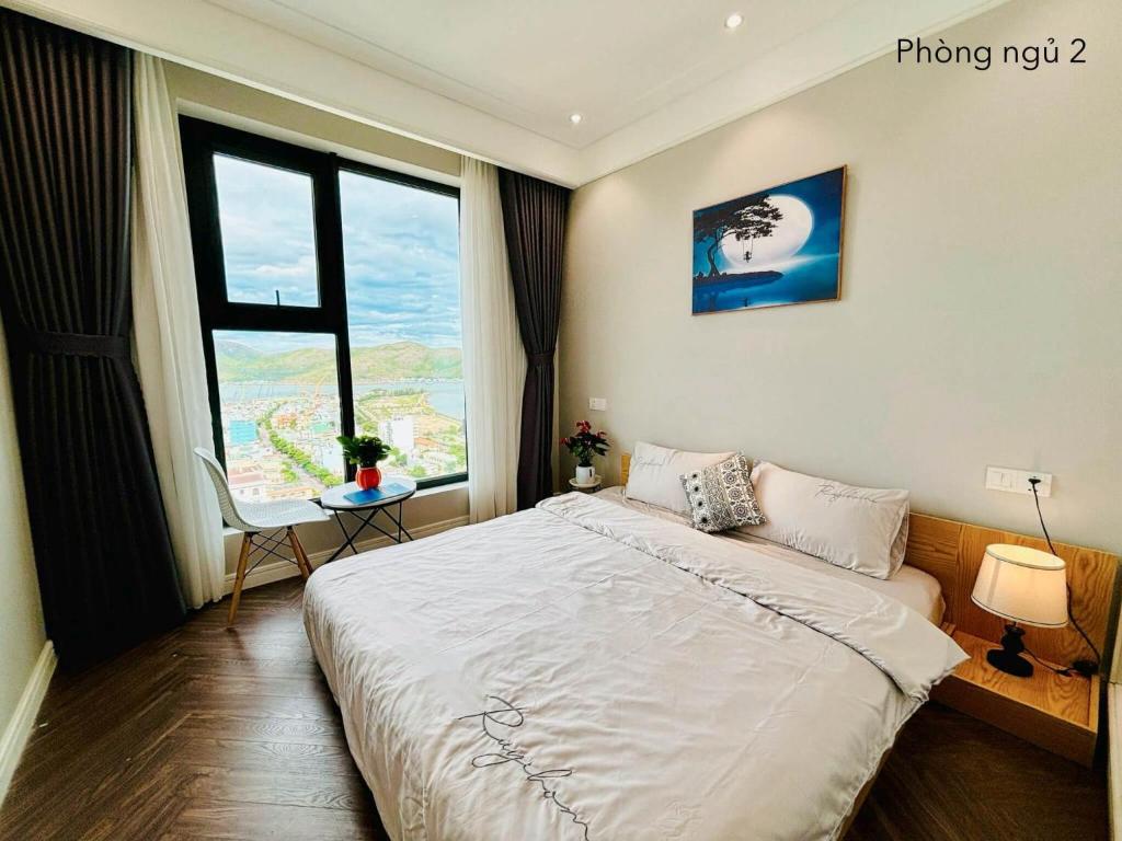 una camera da letto con un letto grande e una finestra di ALTARA Residences Quy Nhơn-Sam n' Sea Apartment-Căn hộ homestay view biển có hồ bơi a Quy Nhon