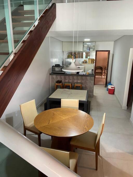 ein Esszimmer mit Tisch und Stühlen und eine Küche in der Unterkunft Casa na praia do coqueiro in Luis Correia