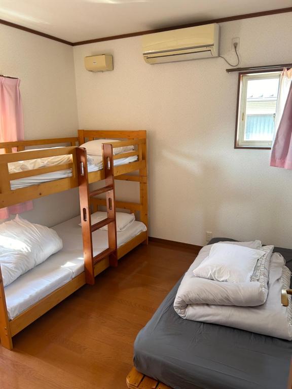 Postel nebo postele na pokoji v ubytování GuestHouse AIZU