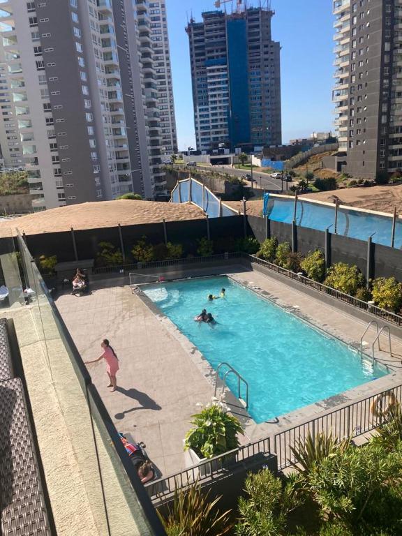 un grupo de personas en una piscina en una ciudad en Cómodo depto concón, en Concón