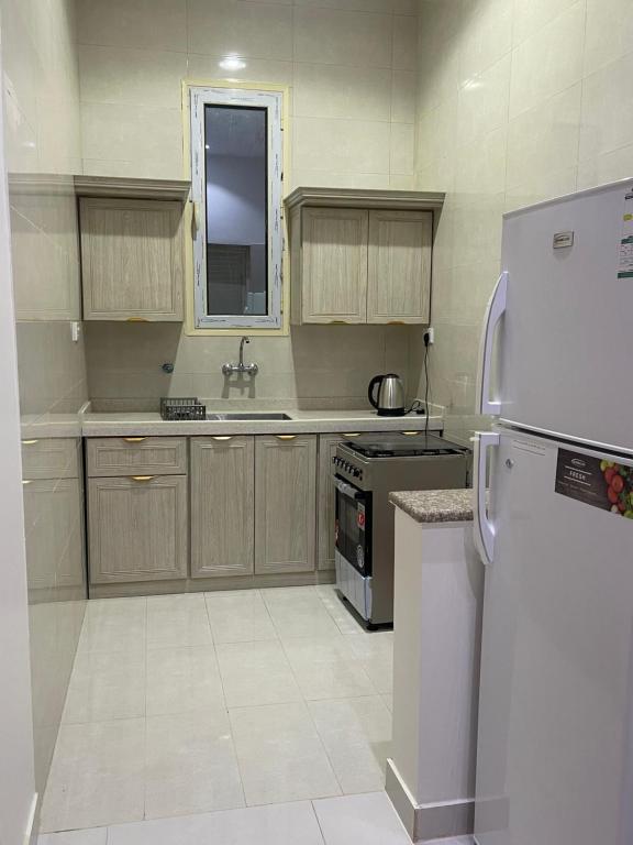 Una cocina con un refrigerador blanco y un fregadero. en الدانه 2, en Hafr Al Batin