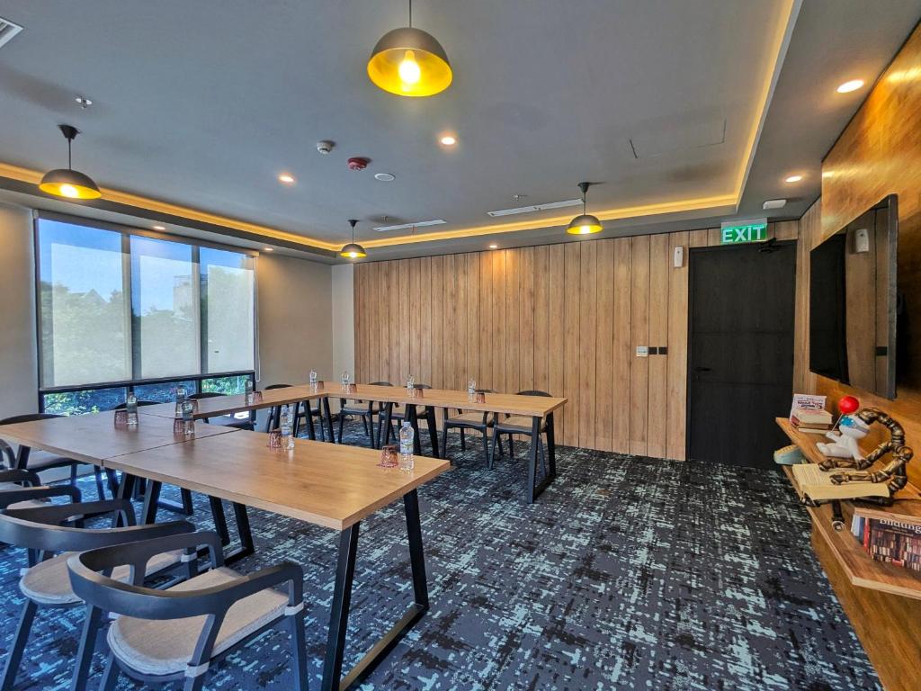 una sala conferenze con tavoli e sedie in legno di Moxy Solo a Solo