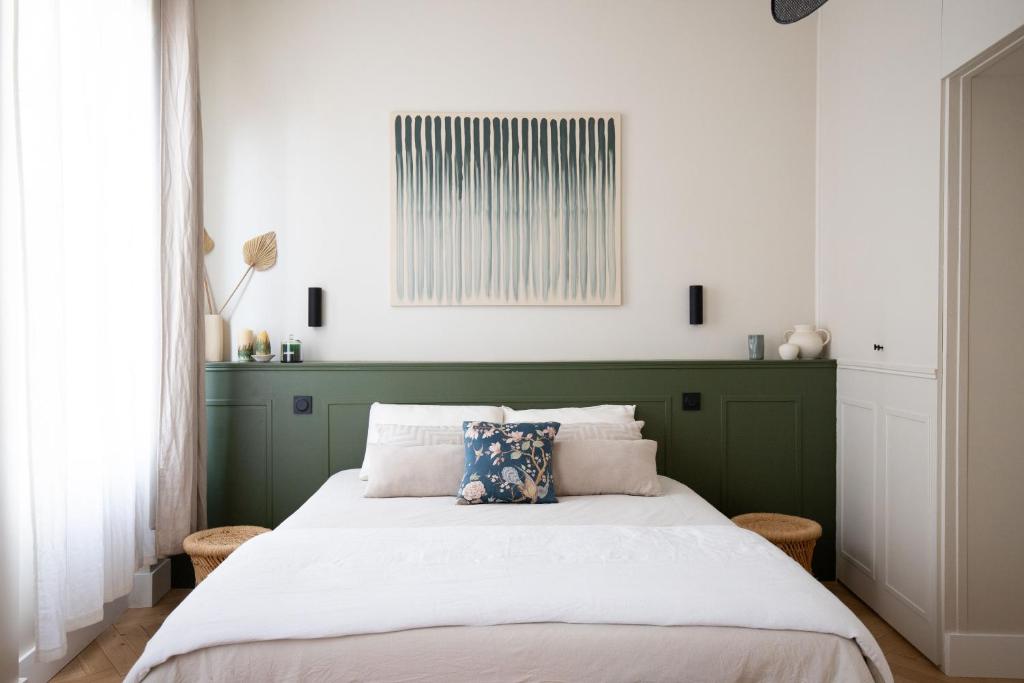 une chambre avec un grand lit avec une tête de lit verte dans l'établissement Superbe Appartement Toulouse hypercentre, à Toulouse