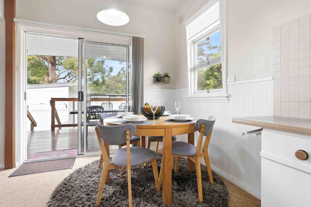 a kitchen and dining room with a table and chairs at Jack's Beach Shack by Experience Jervis Bay in Huskisson