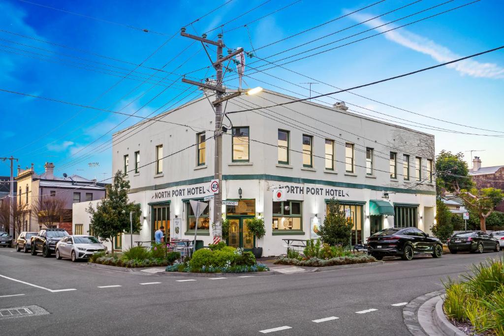 un edificio bianco all'angolo di una strada di North Port Hotel - Boutique Accommodation a Melbourne