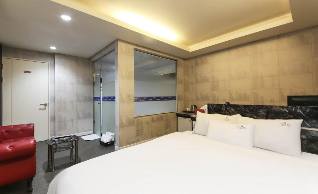 Postel nebo postele na pokoji v ubytování Songjeong V Hotel