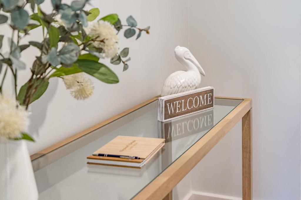 a glass shelf with a white bird on a welcome sign at Shepherds Delight-Access Friendly-Linen Included in Goolwa South