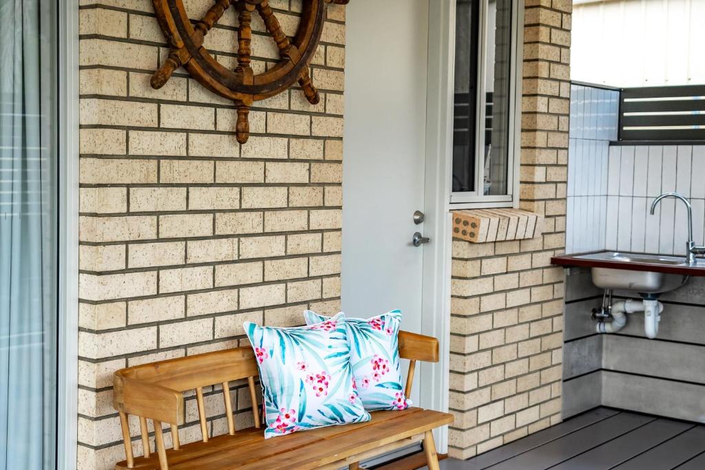 a wooden bench with two pillows on a porch at Shepherds Delight-Access Friendly-Linen Included in Goolwa South