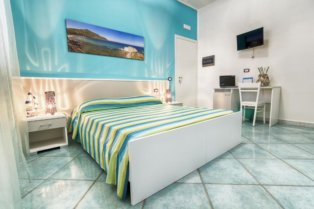 1 dormitorio con 1 cama, escritorio y TV en B&B Casa 28, en Agropoli