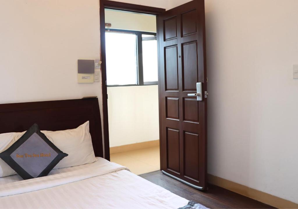 a bedroom with a bed and a open door at Sontra Sea Hotel in Danang