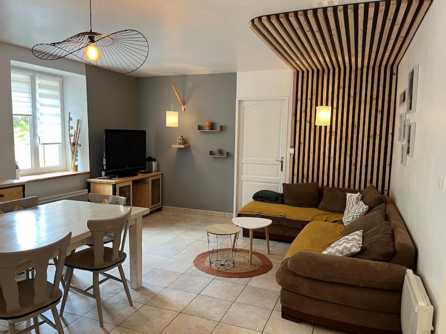 a living room with a couch and a table at Appartement 5 personnes avec espace plein air in Saint-Maurice-sur-Moselle