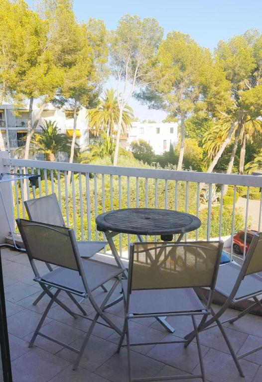 une table et des chaises sur un balcon arboré dans l'établissement Le Coquet T2 à 50 m de la mer, à Saint-Raphaël