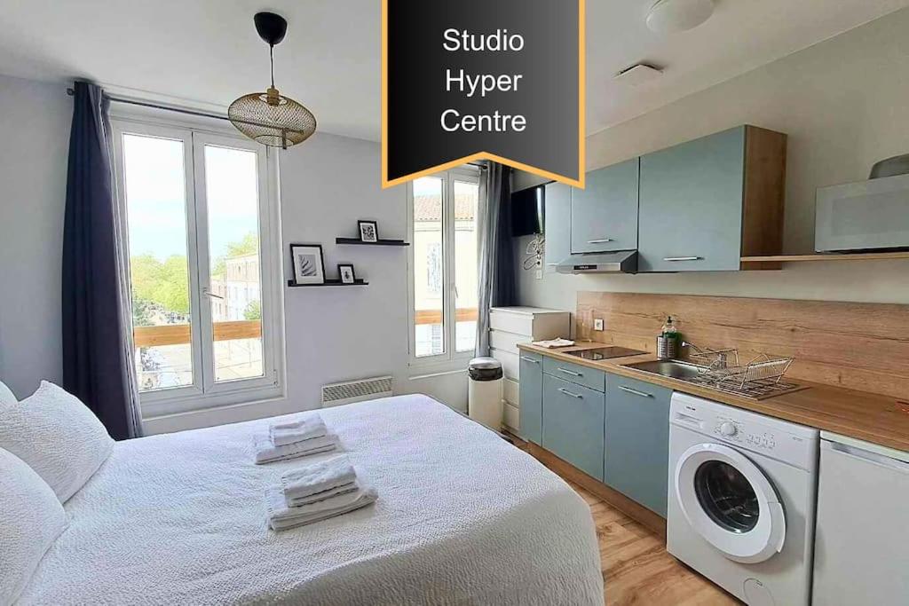 Cet appartement comprend une chambre avec un lit blanc et une cuisine. dans l'établissement Vivent 5 - Studio Agen, à Agen