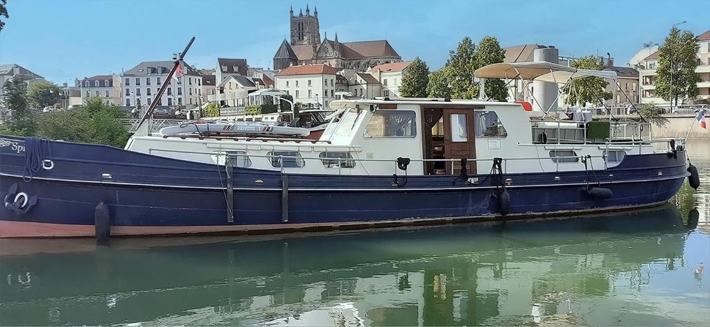 a blue and white boat sitting in the water at Spicy - Séjour insolite sur la Marne in Meaux