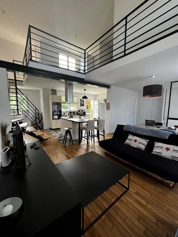 a living room with a bed and a dining room at Maison fraîchement rénovée in Aulnay-sous-Bois