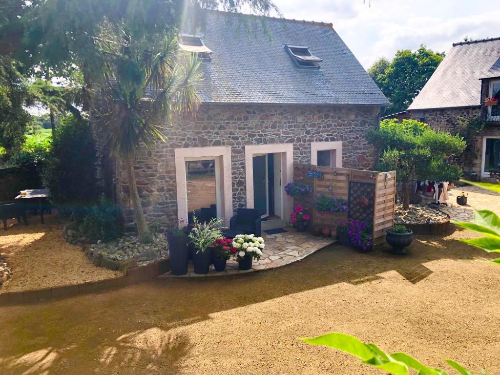une maison en pierre avec des fleurs devant dans l'établissement Le TY VIAN, à Gommenec'h