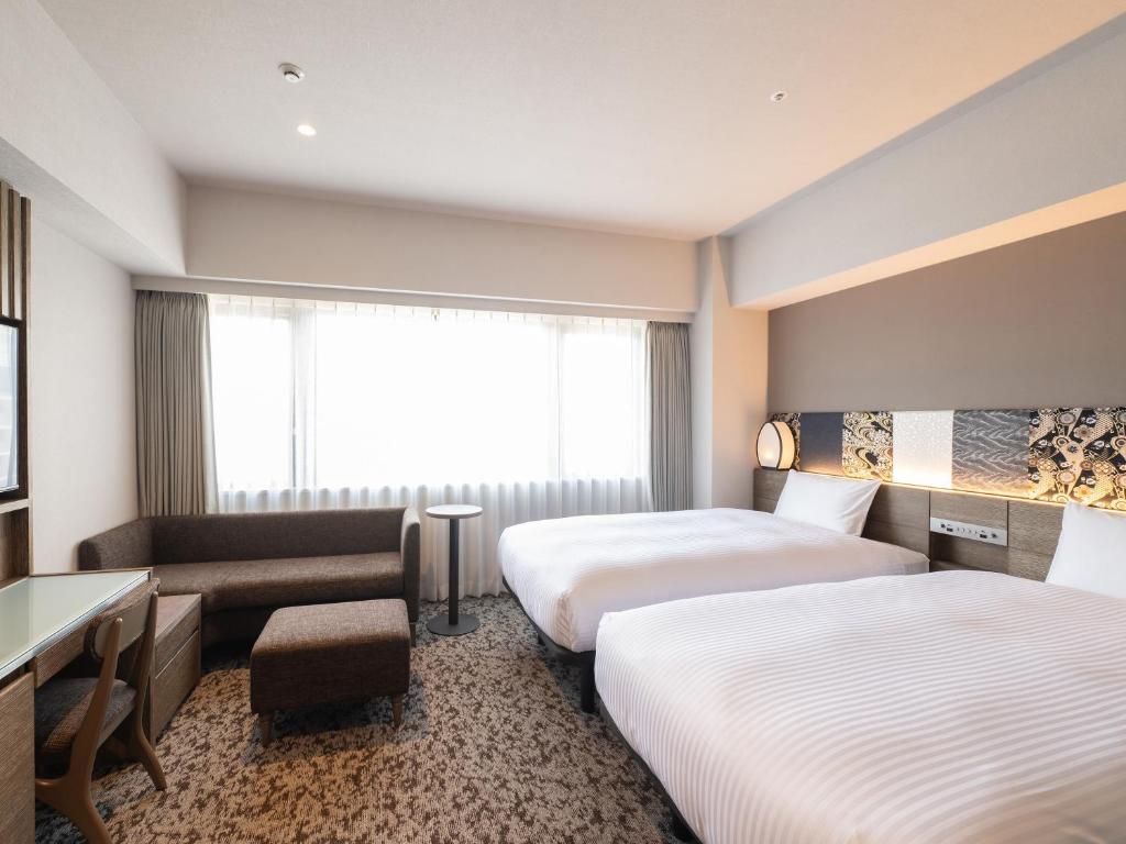 京都市にあるinsomnia KYOTO OIKEのベッドが2つと窓があるホテルの部屋