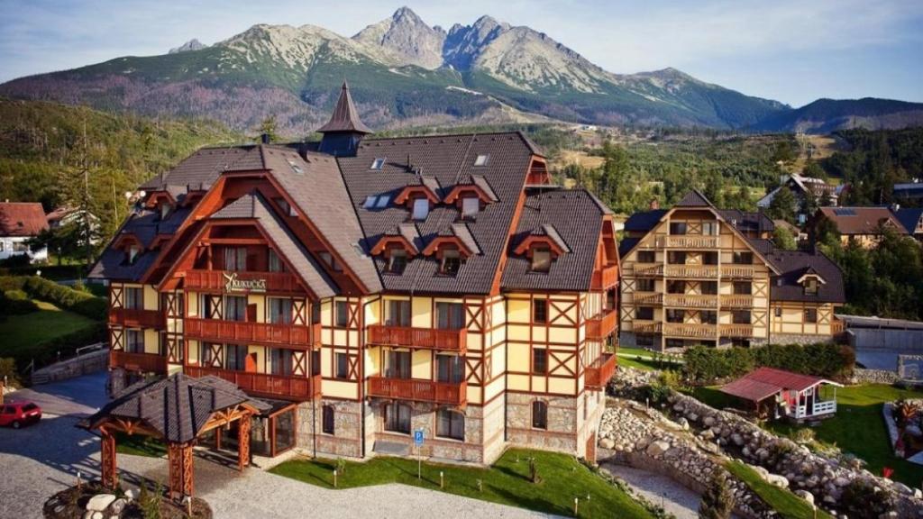 una vista aerea di una grande casa con montagne sullo sfondo di Vysoké Tatry apartmán 309 - Tatranská Lomnica - výhľad na Tatry a Tatranská Lomnica