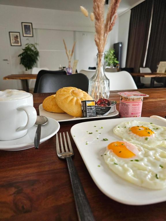 a table with plates of eggs and bread on it at Hotel Fuchs & Hase SELF CHECK IN in Rosegg