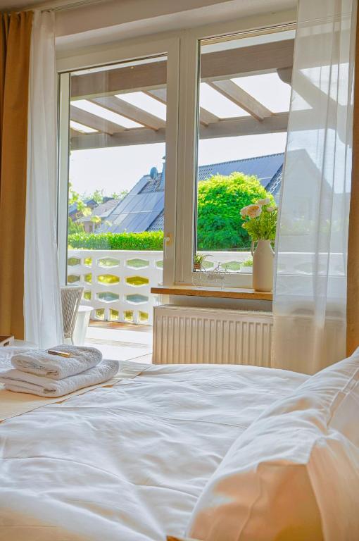 a bedroom with a white bed and a window at Modern & gepflegt, Süd-Terrasse, Parkplatz, Nähe DUS in Kaarst