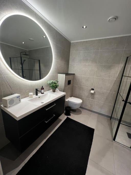 Un baño con lavabo, espejo e inodoro. en Nytt hus i fredfullt nabolag, en Verdal