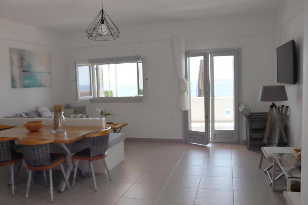 a dining room and living room with a table and chairs at Antigoni Villas in Gavrio