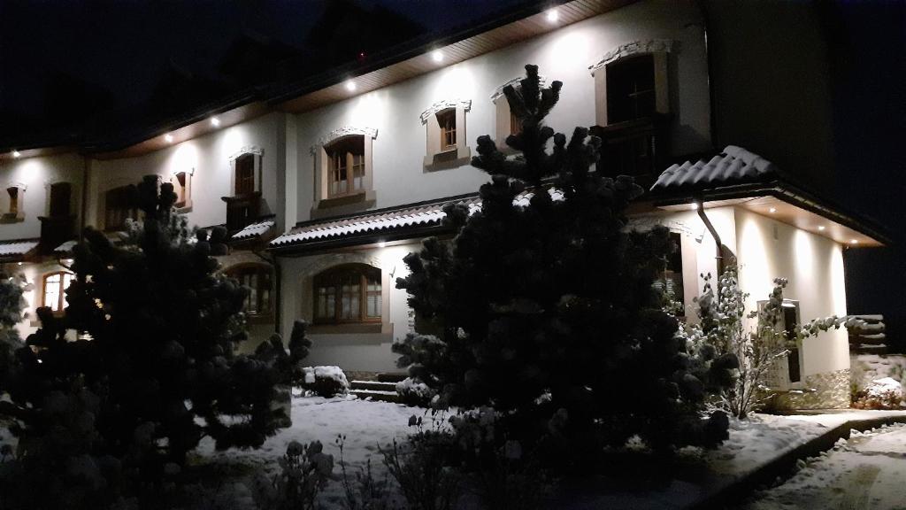 a house with snow on the ground in front of it at Dom przy stoku 2 in Bałtów