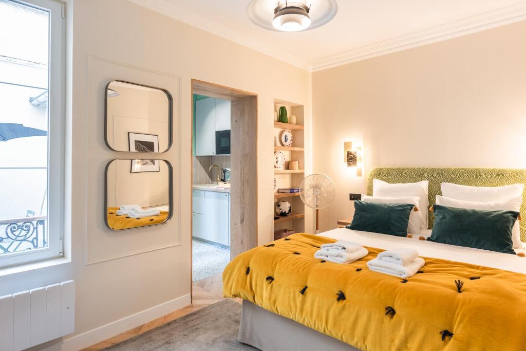 une chambre avec un grand lit et un miroir dans l'établissement Charming Studio with terrace - Near Montmartre, à Paris