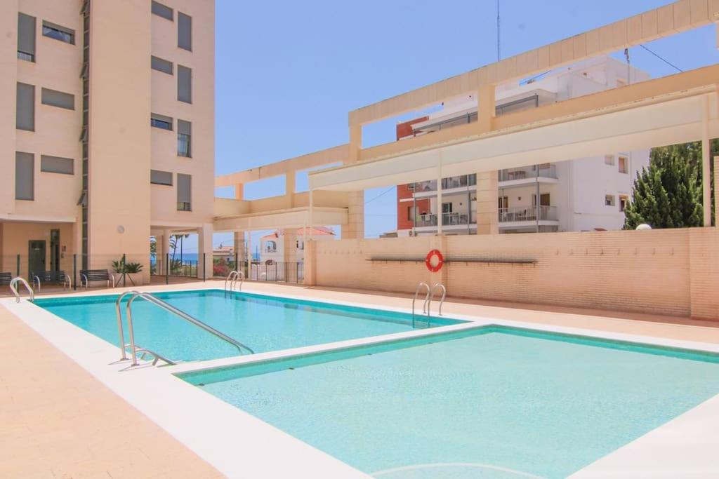 a swimming pool in front of a building at Apartamento con piscina - Plazamayor 251 in Calpe