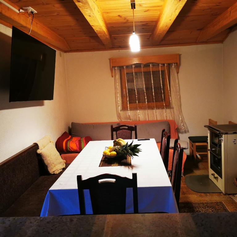 a dining room with a table and a couch at Kuća za odmor Tomislav in Trnovdc