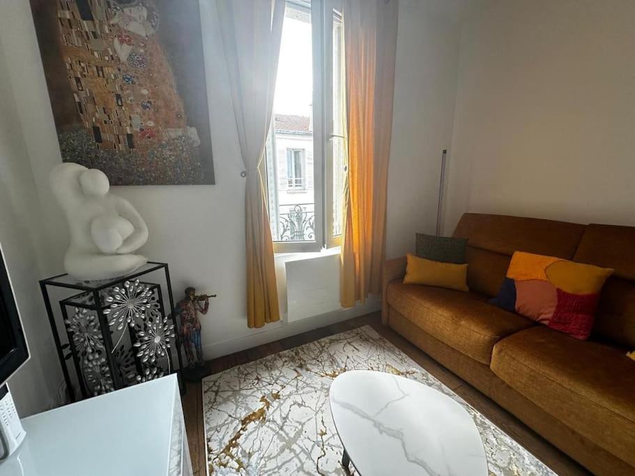 un salon avec un canapé et une fenêtre dans l'établissement Appartement lumineux #612, à Malakoff