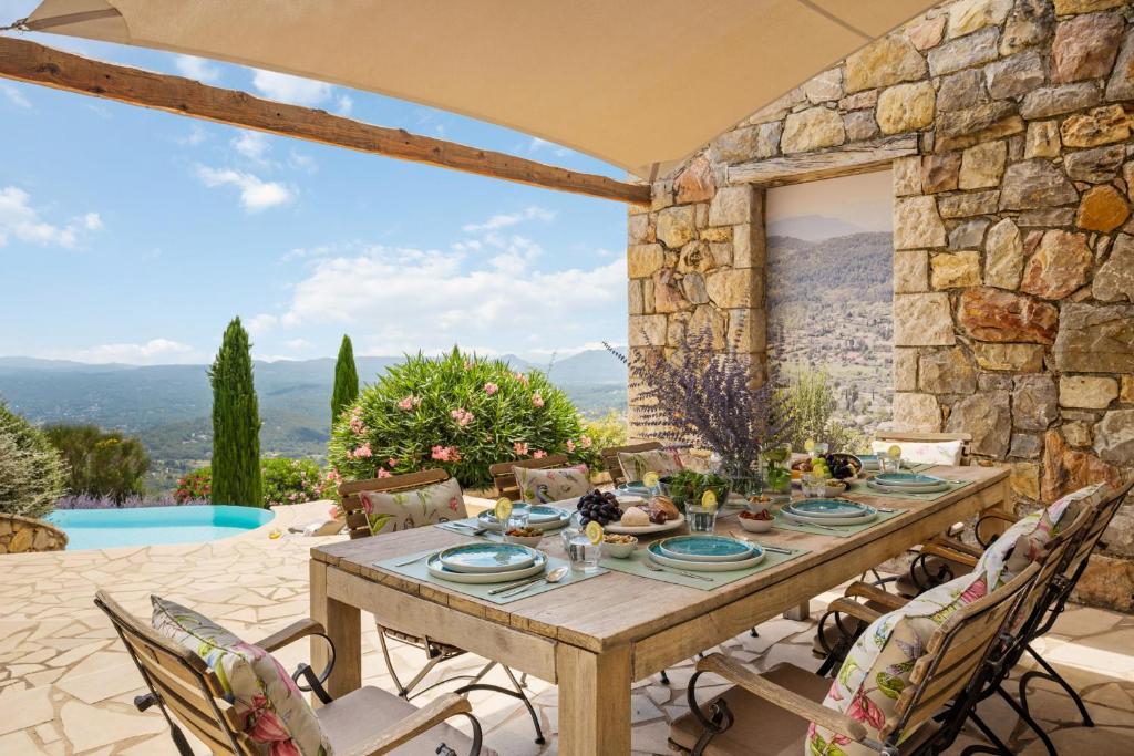 eine steinerne Terrasse mit einem Tisch und Stühlen in der Unterkunft Villa La Genestière - Familienoase und Golfertraum mit Infinity-Pool und 180-Grad-Panoramablick bis zum Meer in Seillans