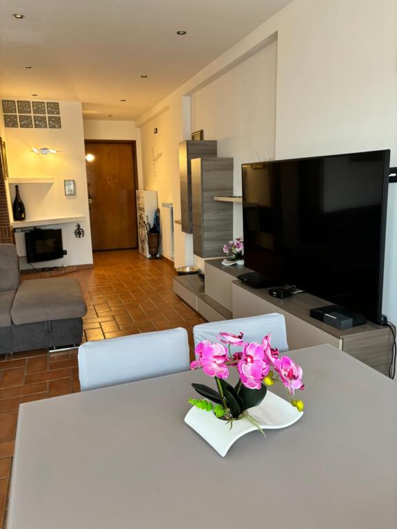 - un salon avec une table ornée de fleurs roses dans l'établissement Casa Giulietta, à Nettuno