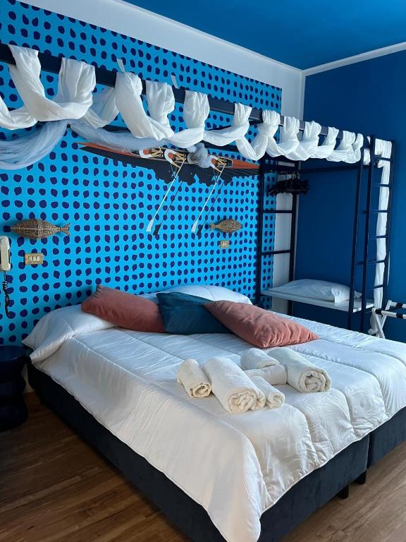 a bedroom with a bed with a blue wall at Hotel Adriatica sul Mare in Rimini