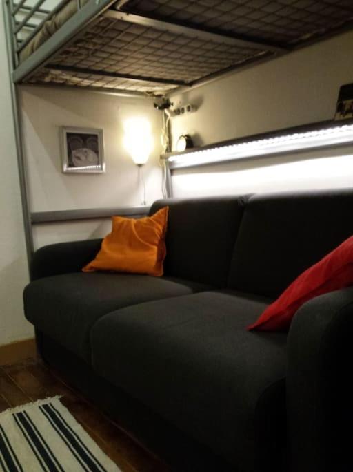 un canapé avec un coussin orange dessus dans une pièce dans l'établissement Studio central, à Paris