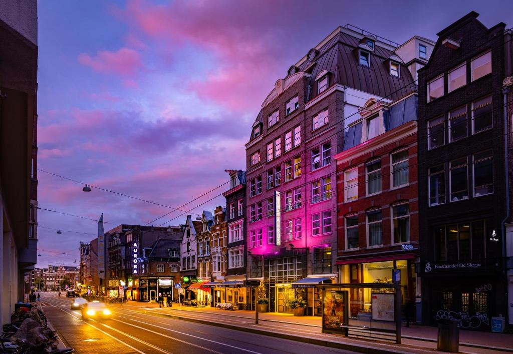 a city street at night with buildings and cars at Boutique Hotel Albus Amsterdam Centre in Amsterdam