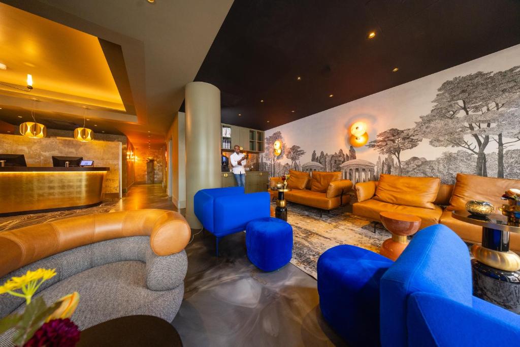 een lobby met blauwe en oranje meubels en een muurschildering bij Boutique Hotel Albus Amsterdam Centre in Amsterdam
